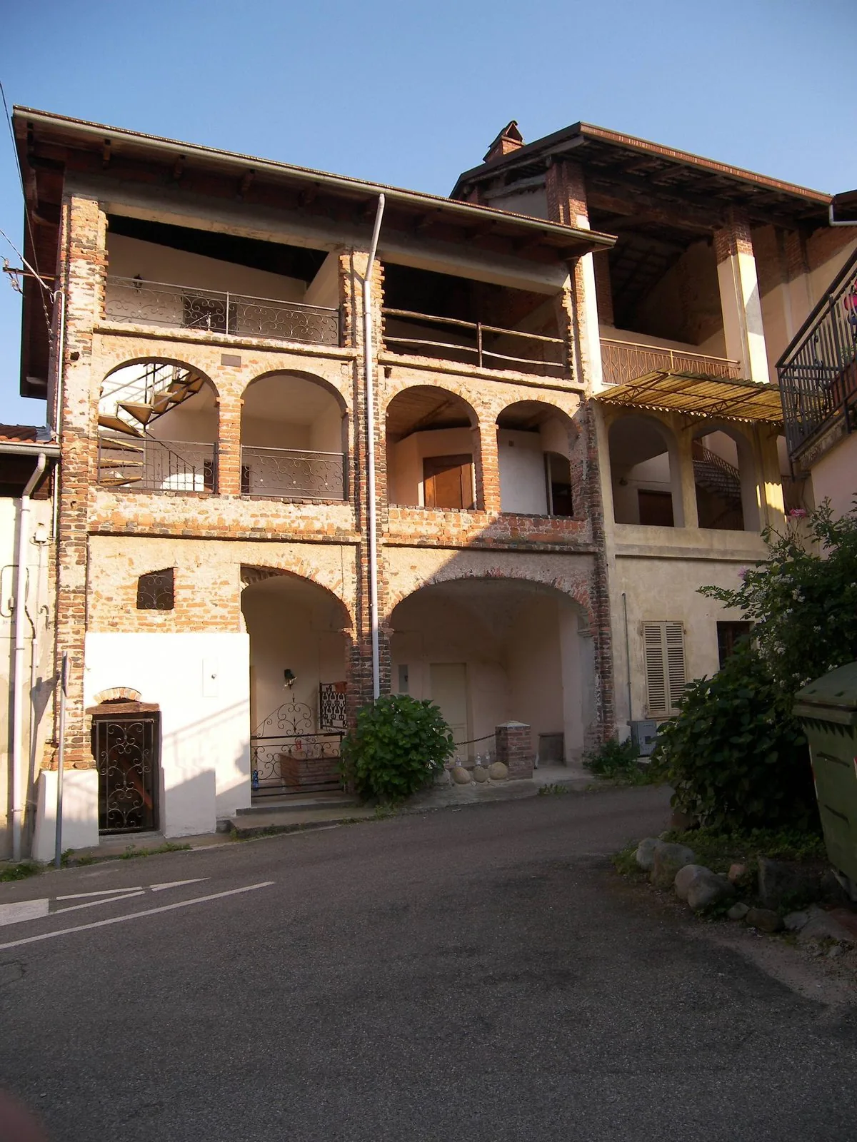 Una casa storica con loggiato in mattoni in un paese vicino a Roasio