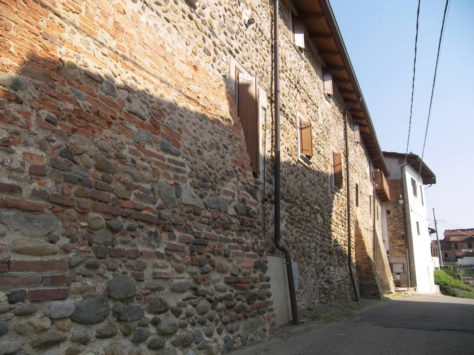 Un muro in ciottoli e mattoni lungo una strada dei paesi intorno a Roasio